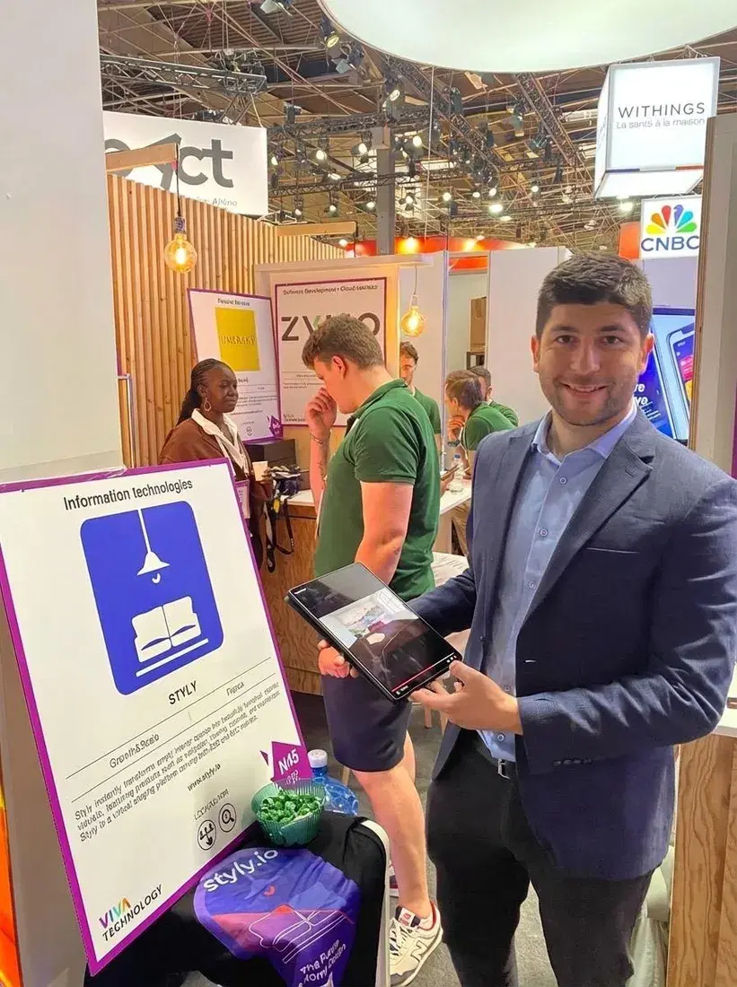 STYLY founder demonstrating the product on a tablet at the VivaTech stand
